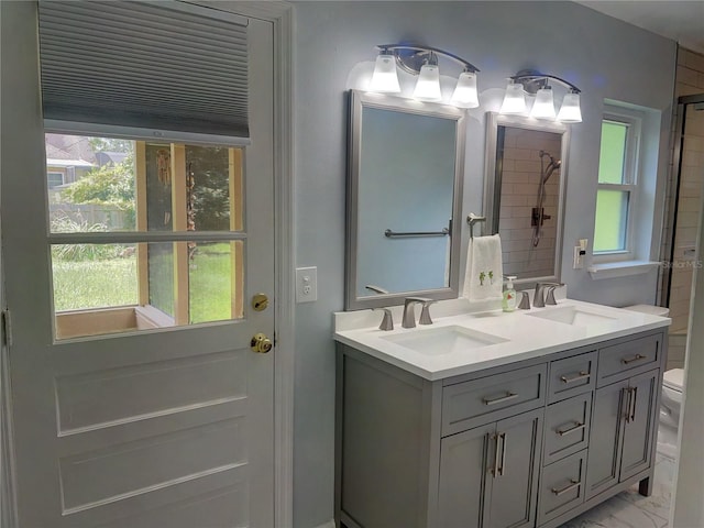 bathroom with toilet and dual bowl vanity