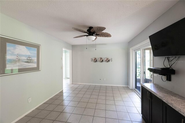 tiled spare room with ceiling fan and a textured ceiling