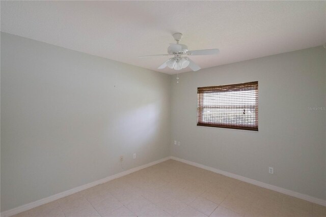 tiled spare room with ceiling fan