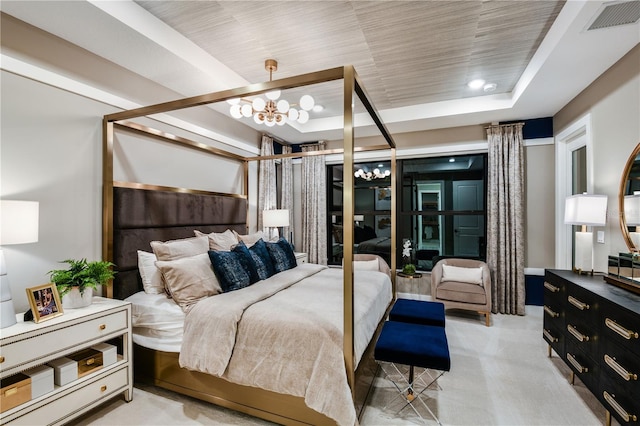 bedroom with a raised ceiling and a chandelier