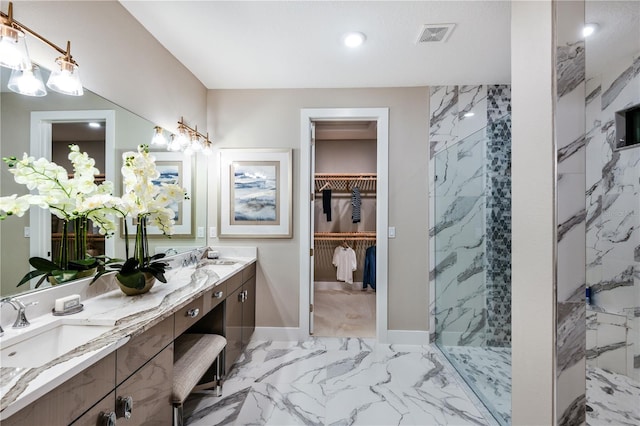 bathroom featuring tile patterned flooring, double vanity, and a tile shower