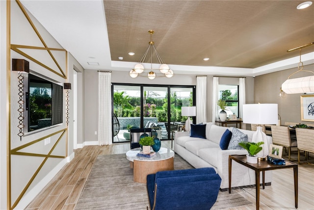 living room with light hardwood / wood-style floors and a tray ceiling