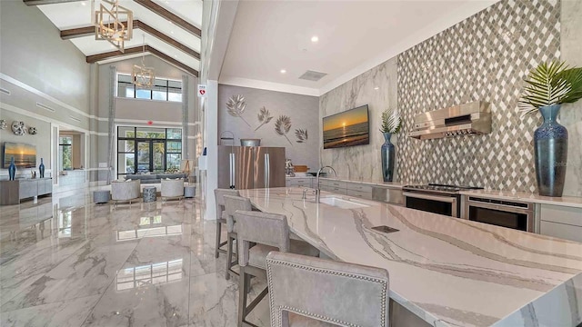 4910 Carova Way, Lakewood Ranch, FL 34211 - interior space with an inviting chandelier, a sink, wall chimney exhaust hood, marble finish floor, and stainless steel appliances