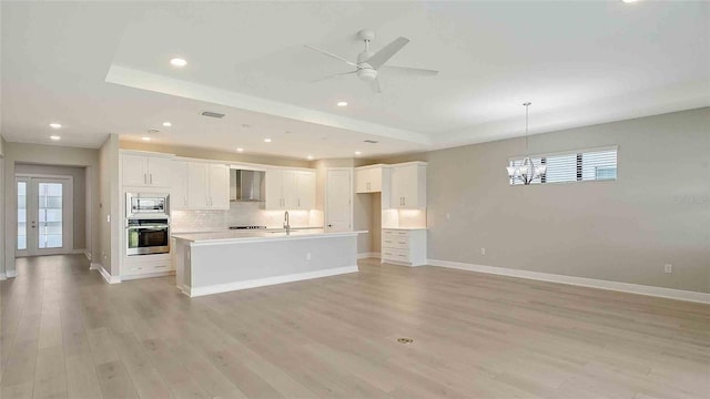 4910 Carova Way, Lakewood Ranch, FL 34211 - kitchen featuring wall chimney range hood, appliances with stainless steel finishes, a sink, baseboards, and tasteful backsplash
