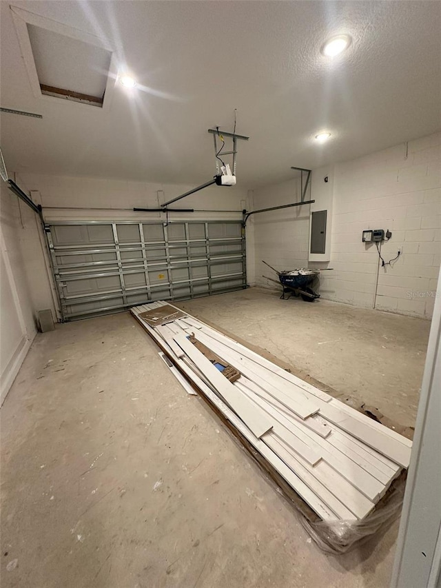 garage with a garage door opener and electric panel