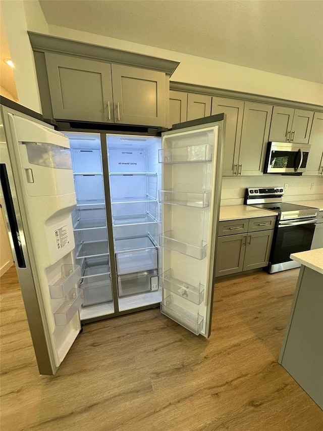 kitchen featuring gray cabinetry, stainless steel appliances, and light hardwood / wood-style floors