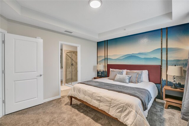 carpeted bedroom with baseboards, visible vents, connected bathroom, and a raised ceiling