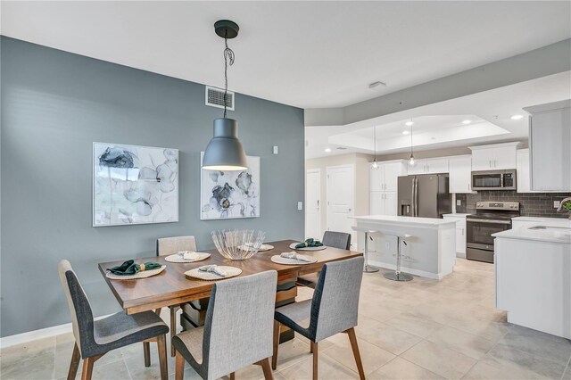 dining area with recessed lighting, visible vents, baseboards, and a tray ceiling