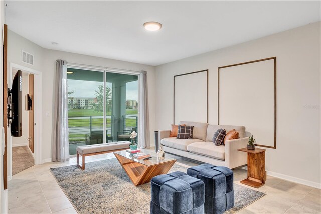 living room with visible vents, baseboards, and light tile patterned floors