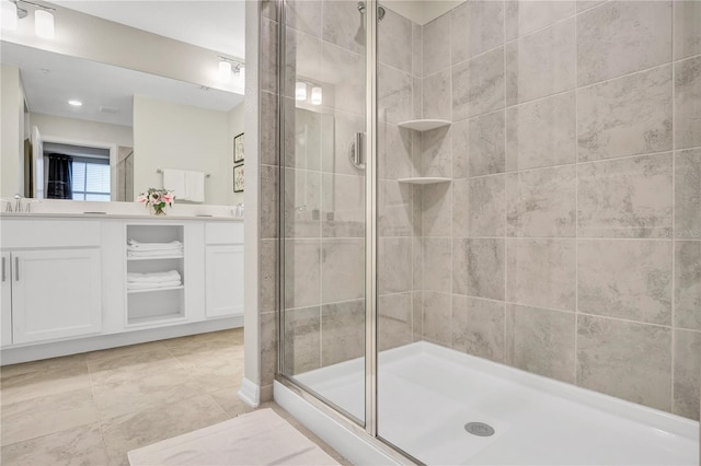 bathroom featuring an enclosed shower, vanity, and tile patterned flooring