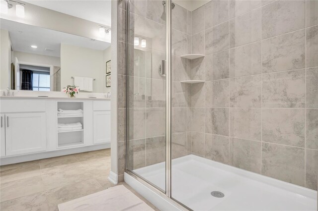 bathroom with a sink, double vanity, and a stall shower