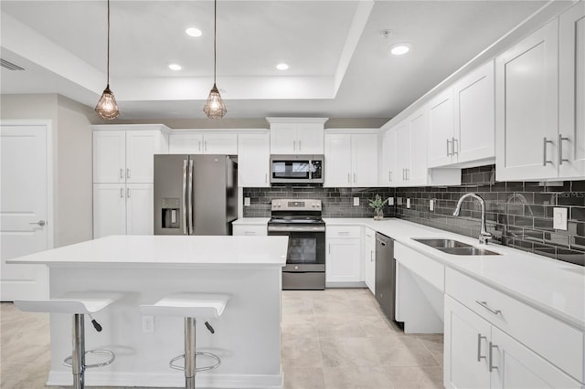 kitchen featuring tasteful backsplash, pendant lighting, light tile patterned flooring, stainless steel appliances, and white cabinets