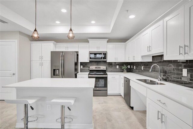 kitchen with backsplash, white cabinets, stainless steel appliances, and a sink
