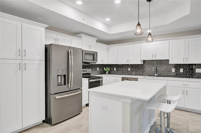 kitchen featuring decorative backsplash, appliances with stainless steel finishes, light tile patterned floors, a tray ceiling, and sink