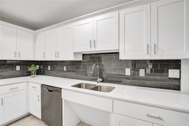 kitchen featuring dishwasher, white cabinets, a sink, and light countertops