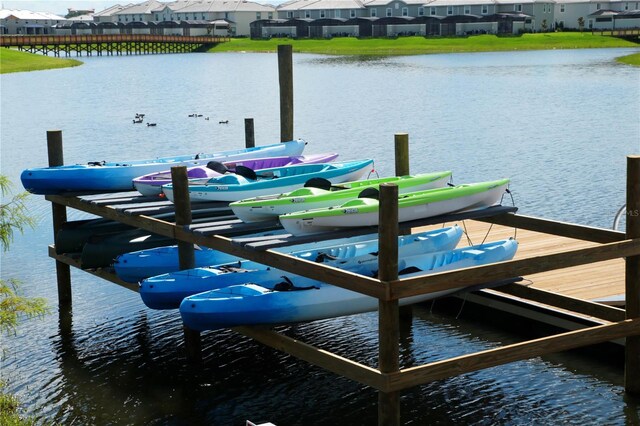 view of dock with a residential view and a water view