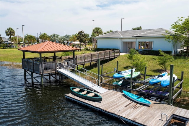 view of dock with a yard, a water view, and a gazebo