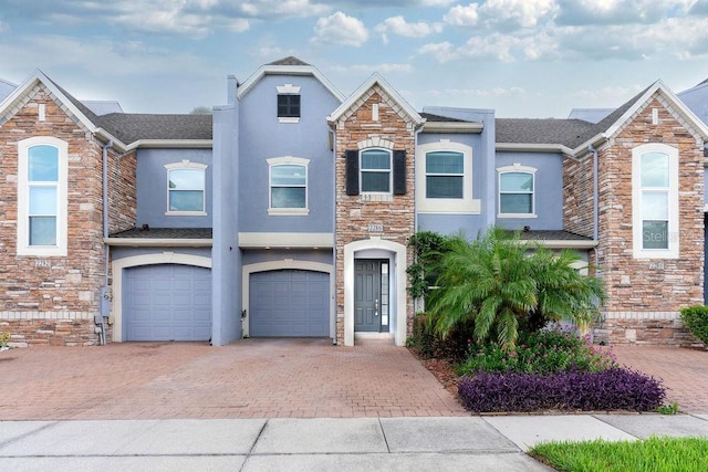 view of front of property with driveway, an attached garage, and stucco siding