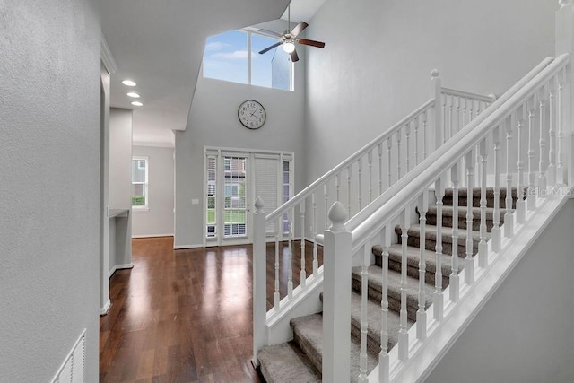 staircase featuring hardwood / wood-style floors, high vaulted ceiling, french doors, and ceiling fan