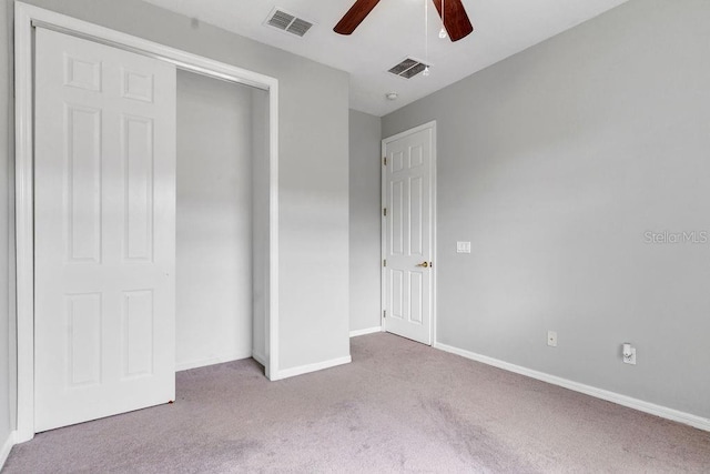 unfurnished bedroom with baseboards, visible vents, a closet, and light colored carpet