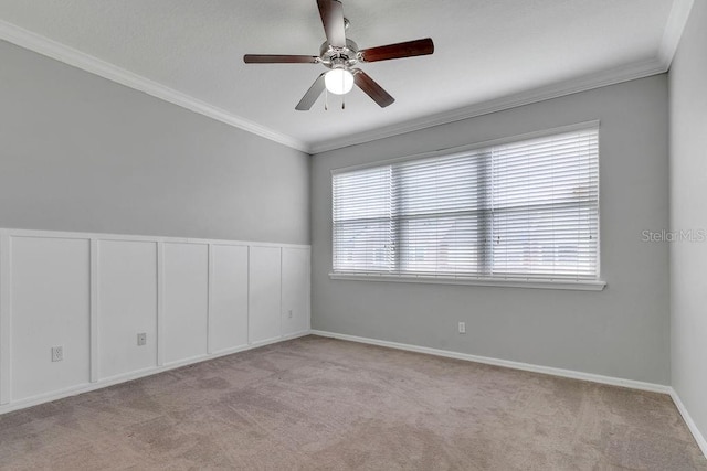 unfurnished room with light carpet, crown molding, baseboards, and ceiling fan