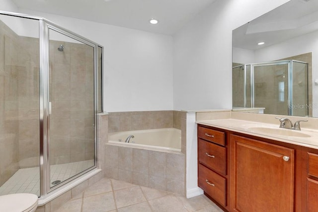 bathroom featuring tile patterned floors, toilet, vanity, a shower stall, and a bath