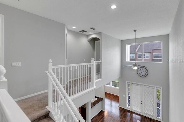 stairway featuring ceiling fan and hardwood / wood-style flooring