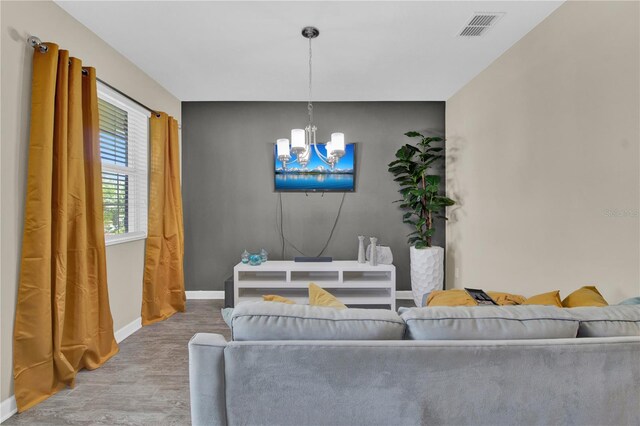 living room with wood-type flooring and an inviting chandelier