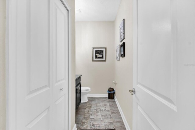 bathroom with hardwood / wood-style flooring, toilet, and vanity