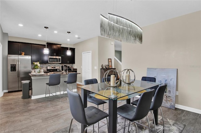 dining space featuring sink and light hardwood / wood-style flooring