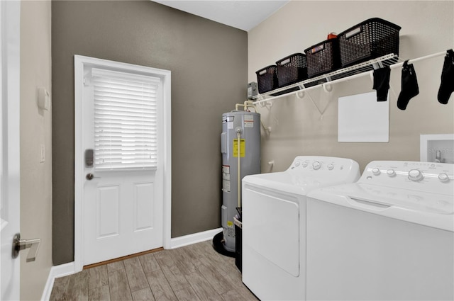 laundry area with washing machine and dryer, water heater, and light hardwood / wood-style floors