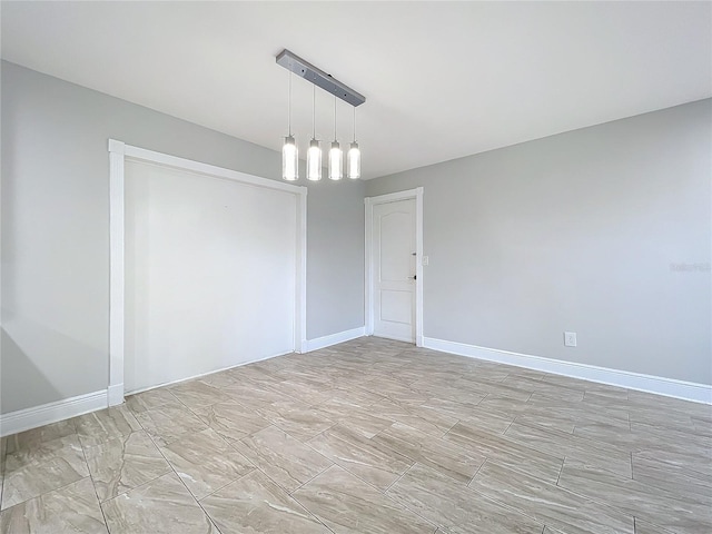 spare room with baseboards