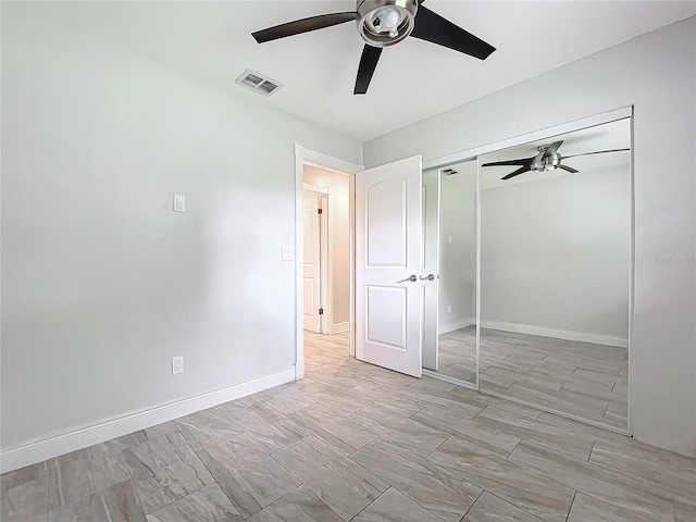 unfurnished bedroom with a closet, visible vents, ceiling fan, and baseboards