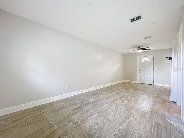 empty room with visible vents, baseboards, and ceiling fan