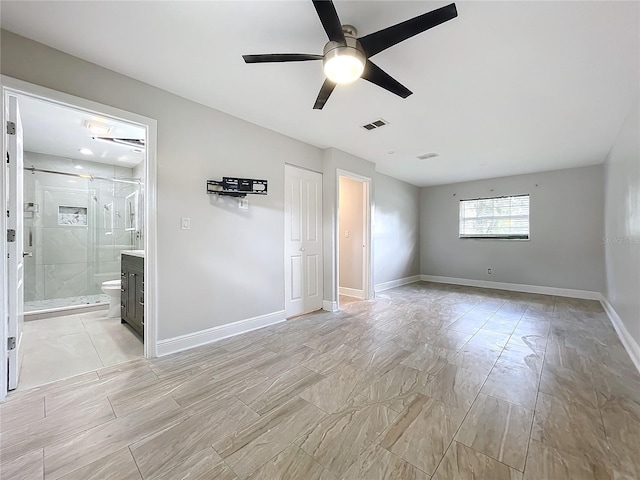 unfurnished bedroom featuring a ceiling fan, baseboards, visible vents, and ensuite bathroom