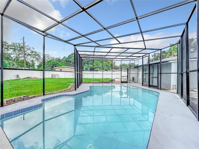 view of swimming pool featuring glass enclosure, a patio, a fenced in pool, a yard, and a fenced backyard