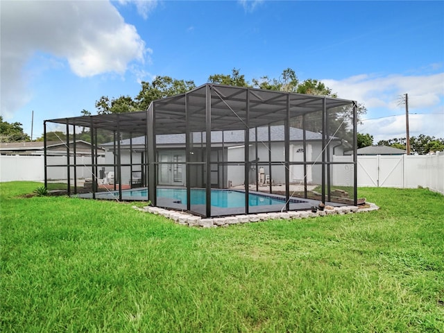 exterior space featuring a lanai, a fenced in pool, a fenced backyard, and a lawn