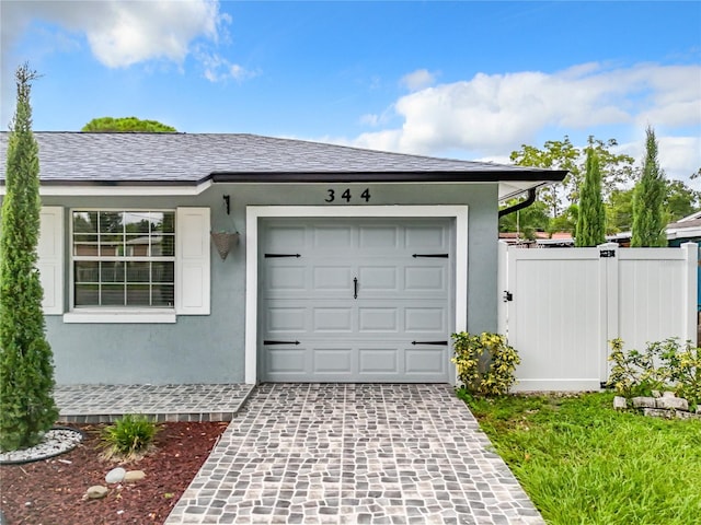 garage featuring fence and driveway