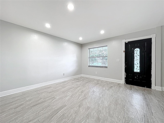 foyer entrance with recessed lighting and baseboards