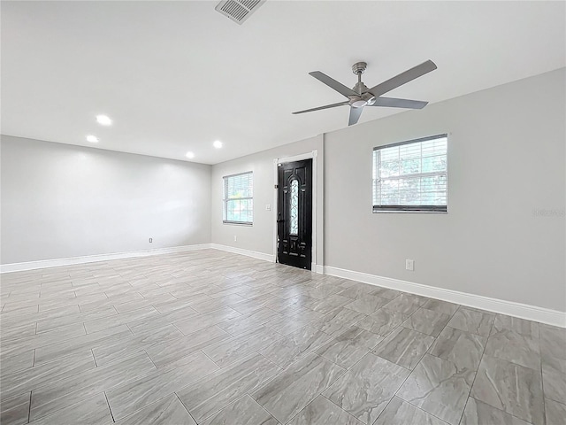 unfurnished room with visible vents, baseboards, a healthy amount of sunlight, and a ceiling fan