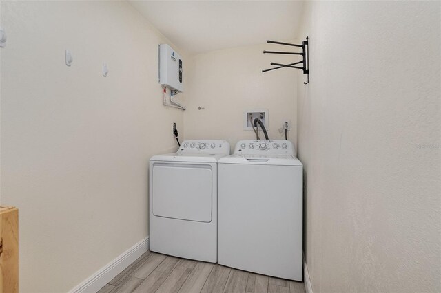 clothes washing area featuring baseboards, laundry area, light wood-style floors, and washer and dryer