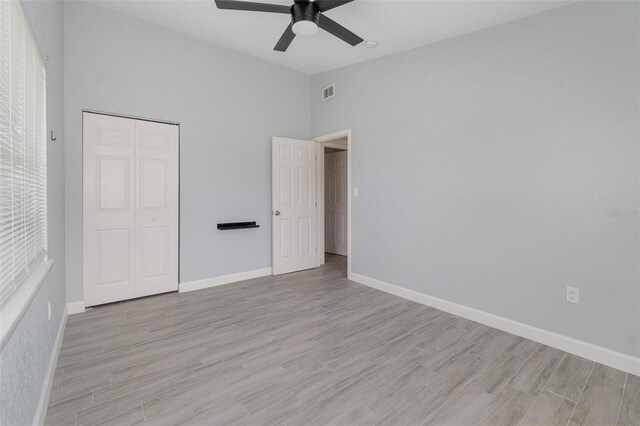 unfurnished bedroom with visible vents, a closet, light wood-style flooring, and baseboards