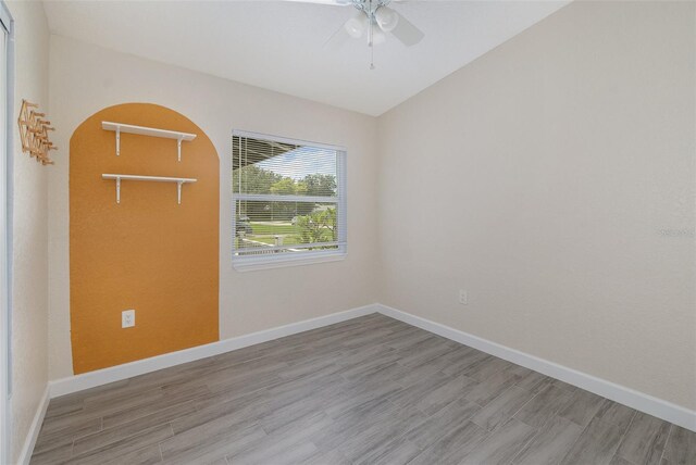 spare room with ceiling fan, baseboards, and wood finished floors