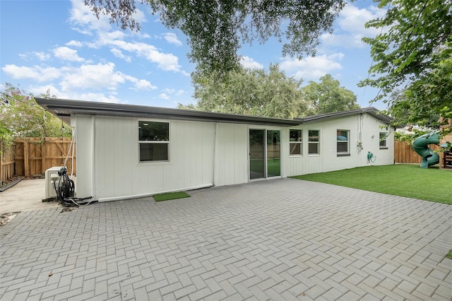 back of property featuring a yard, a patio area, and fence