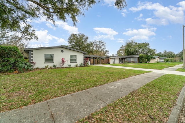 view of front facade with a carport, a front lawn, and concrete driveway