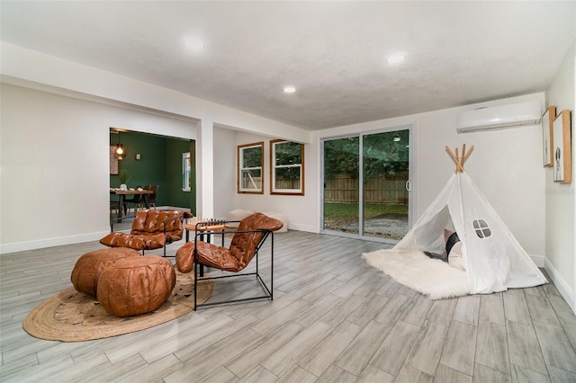 playroom with recessed lighting, baseboards, an AC wall unit, and wood finished floors