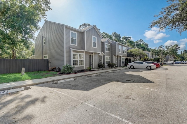 uncovered parking lot with a residential view and fence