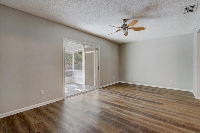 empty room with ceiling fan, visible vents, dark wood finished floors, and baseboards