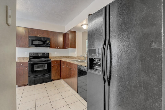 kitchen featuring black appliances, light tile patterned floors, light countertops, and a sink