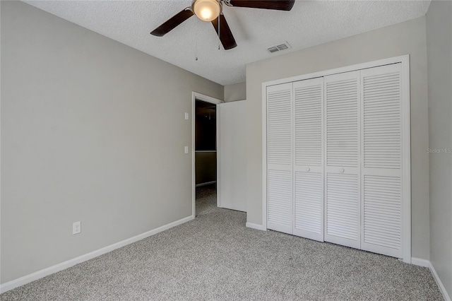 unfurnished bedroom with a textured ceiling, carpet, visible vents, and baseboards